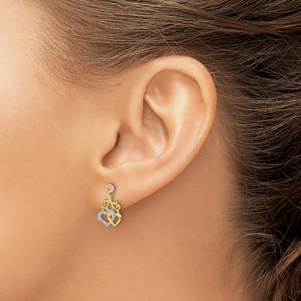 A person wearing a yellow and white gold diamond drop earring with an ornate lattice design, shown in profile from behind.