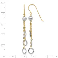 Pair of two-tone gold and silver dangling earrings with polished spheres at the top and textured circular charms at the bottom, displayed on a measurement scale.