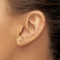A person wearing a heart-shaped gold stud earring with a textured border, shown from the side view of their ear.