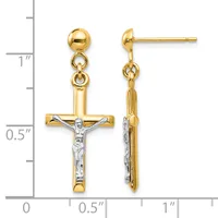 Two-tone gold crucifix earrings with white rhodium-plated corpus, dangling from ball posts with jump ring connectors, shown against a measurement scale.