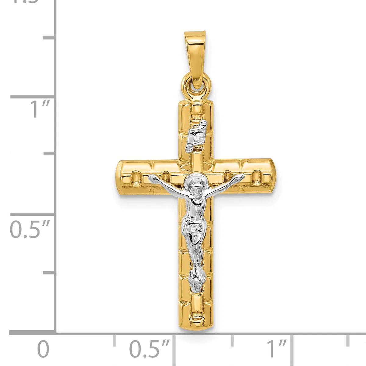 Two-tone gold cross pendant with a white gold crucifix figure, displayed against a measurement scale showing approximately one inch in height.