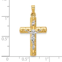 Two-tone gold cross pendant with a white gold crucifix figure, displayed against a measurement scale showing approximately one inch in height.