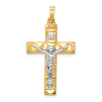 Two-tone gold crucifix pendant with a polished yellow gold cross and a white gold corpus figure, featuring a small stamped hallmark near the top bail.