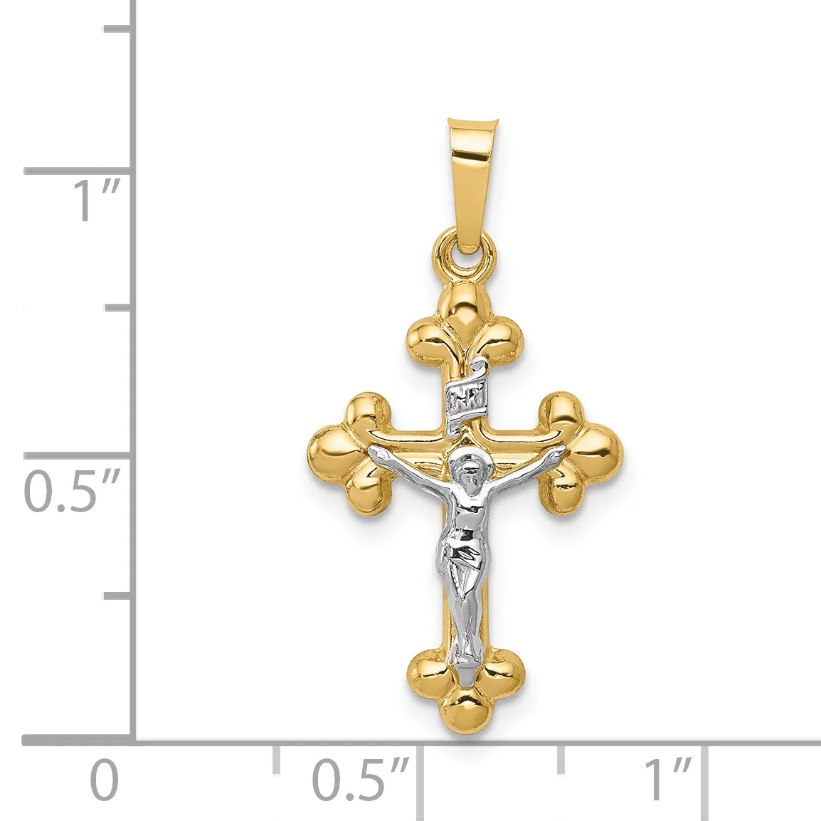 Two-tone gold crucifix pendant with white gold corpus and gold fleur-de-lis terminals, shown against a ruler measuring approximately 1 inch in height.