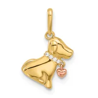 A gold dog charm pendant with a decorative collar set with small diamonds and a small rose gold heart charm hanging below.