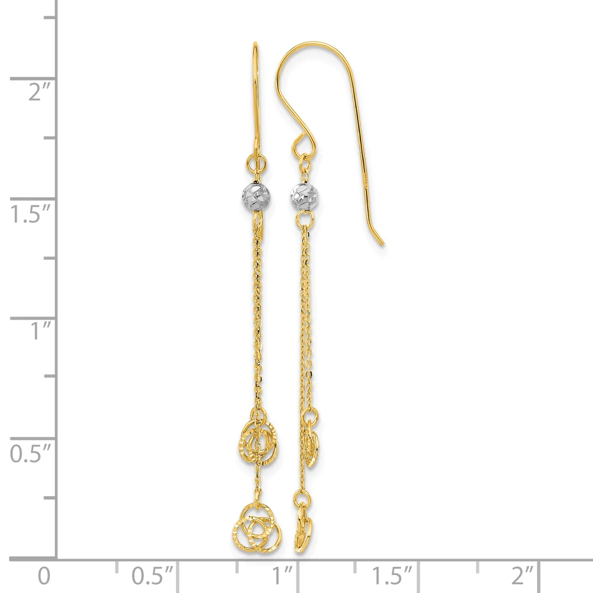 Two gold dangle earrings with chain links, diamond-cut beads, and decorative teardrop charms, displayed against a measurement scale.