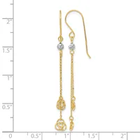 Two gold dangle earrings with chain links, diamond-cut beads, and decorative teardrop charms, displayed against a measurement scale.