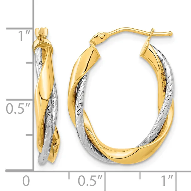 Two-tone gold twisted oval hoop earrings with yellow gold outer surfaces and white gold textured inner surfaces, displayed next to a ruler showing approximately one inch in length.