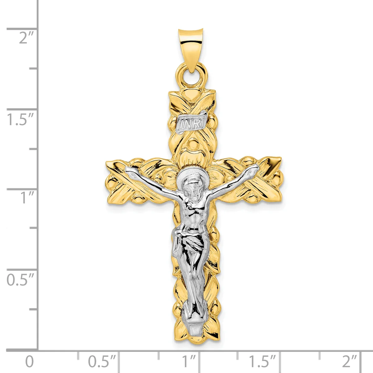 Two-tone gold crucifix pendant with ornate twisted gold borders and a silver-toned corpus, shown against a ruler measuring approximately two inches tall.