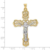 Two-tone gold and silver crucifix pendant with ornate filigree leaf-design arms and a corpus figure, shown against a ruler measuring approximately 2 inches tall.