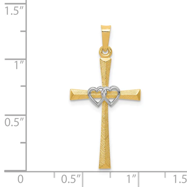 A gold cross pendant with a textured finish and two interlocking hearts in white gold at the center, shown against a measurement scale indicating approximately 1.25 inches in length.