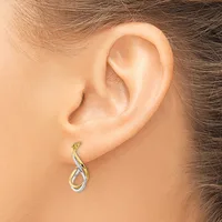 A two-tone twisted hoop earring with a small post and backing worn on a person's earlobe.