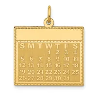 Gold calendar pendant with decorative border showing a month layout with days of the week and numbered dates, with a loop attachment at the top.