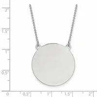 A polished silver circular pendant hangs from a delicate chain, shown against a ruler measuring approximately 2 inches in total length.