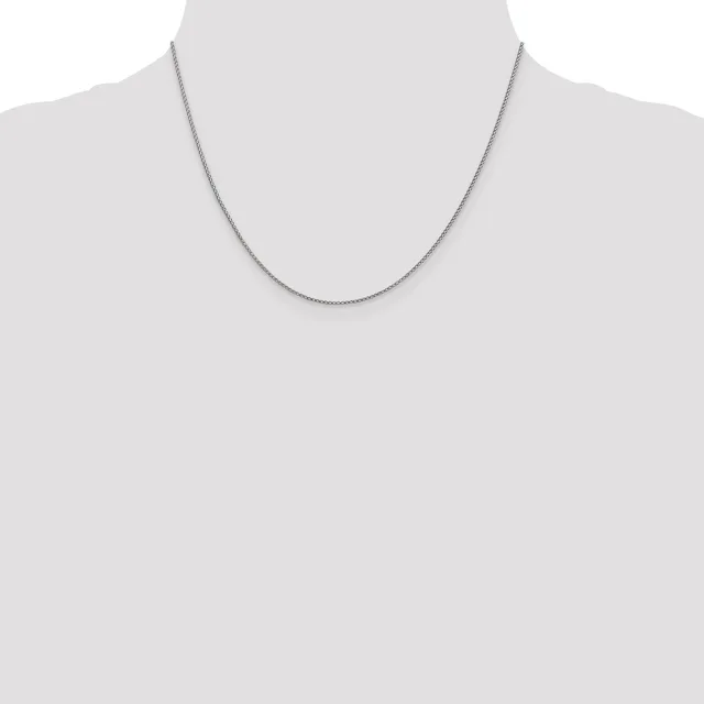 A thin silver chain necklace displayed on a mannequin torso against a white background.