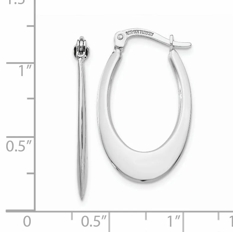 A pair of polished silver oval hoop earrings with a hinged closure, displayed next to a ruler showing approximately one inch in length.