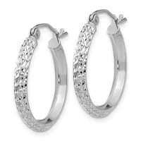 A pair of silver hoop earrings with a textured diamond-cut pattern on the outer surface and smooth polished finish on the inner surface, shown from the front.
