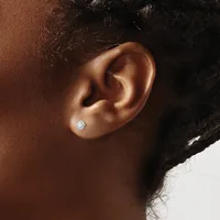 A person with dark skin and curly dark hair wears a small round diamond stud earring in their earlobe, shown in profile against a white background.