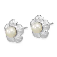 A pair of silver flower-shaped stud earrings, each featuring a cream-colored pearl in the center surrounded by petaled silver settings.