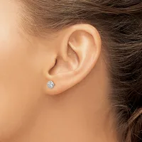 A person wearing a small round diamond stud earring in their pierced earlobe, shown in profile against their neck and shoulder.
