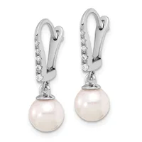 Pair of silver drop earrings with diamond-set hooks and white pearl pendants hanging below.