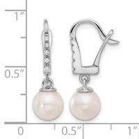Pair of white metal drop earrings with diamond-accented tops and round white pearl bottoms, shown against a measurement scale indicating approximately one inch in length.