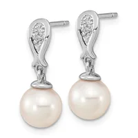 Pair of silver drop earrings with diamond-paved teardrop tops and cream pearl spheres suspended below, shown from the front.