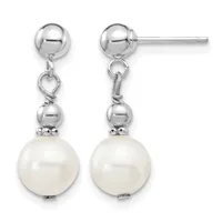 Pair of silver drop earrings with polished ball studs, heart-shaped connectors, smaller silver beads, and large cream-colored pearl drops, shown from front and back views.