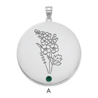 Silver circular pendant with engraved botanical flower design and a small green gemstone at the bottom, suspended from a silver bail.