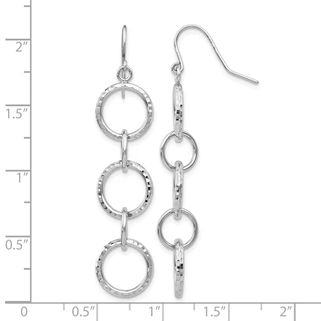 A pair of silver triple-circle dangle earrings with textured rings connected by bars, shown on a ruler measuring approximately two inches long.
