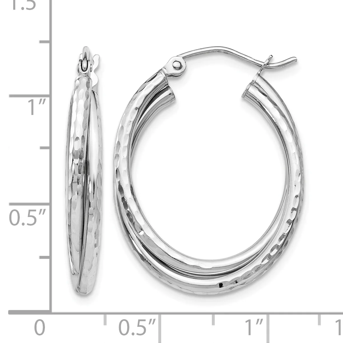 A pair of silver oval hoop earrings with textured surfaces and hinged closures, displayed against a measurement scale showing they are approximately one inch tall.