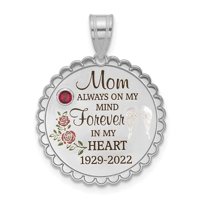 Silver circular pendant with scalloped edges featuring engraved text reading "Mom Always On My Mind Forever In My Heart 1929-2022," decorative roses, a wing design, and a red gemstone, suspended from a silver bail.