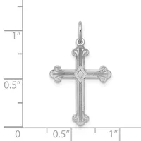 A silver cross pendant with ornate curved ends and a diamond-shaped center detail, shown against a measurement scale indicating approximately one inch in height.