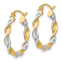 A pair of twisted two-tone gold and silver hoop earrings with textured surfaces and hinged closures.