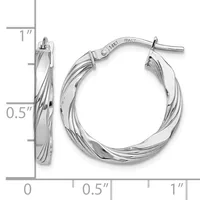 Pair of twisted silver hoop earrings with a small stamped hallmark, shown next to a ruler indicating approximately one inch in diameter.