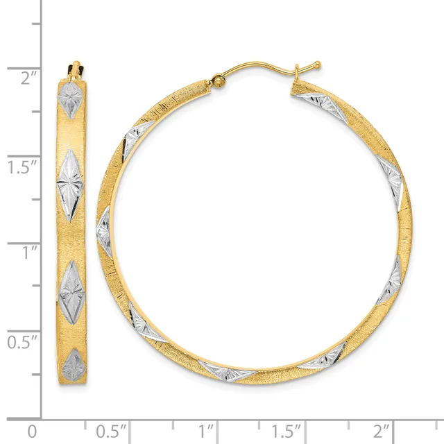 A pair of two-tone gold hoop earrings with textured surfaces and diamond-shaped white metal accents, shown next to a measurement ruler indicating approximately 1.75 inches in diameter.