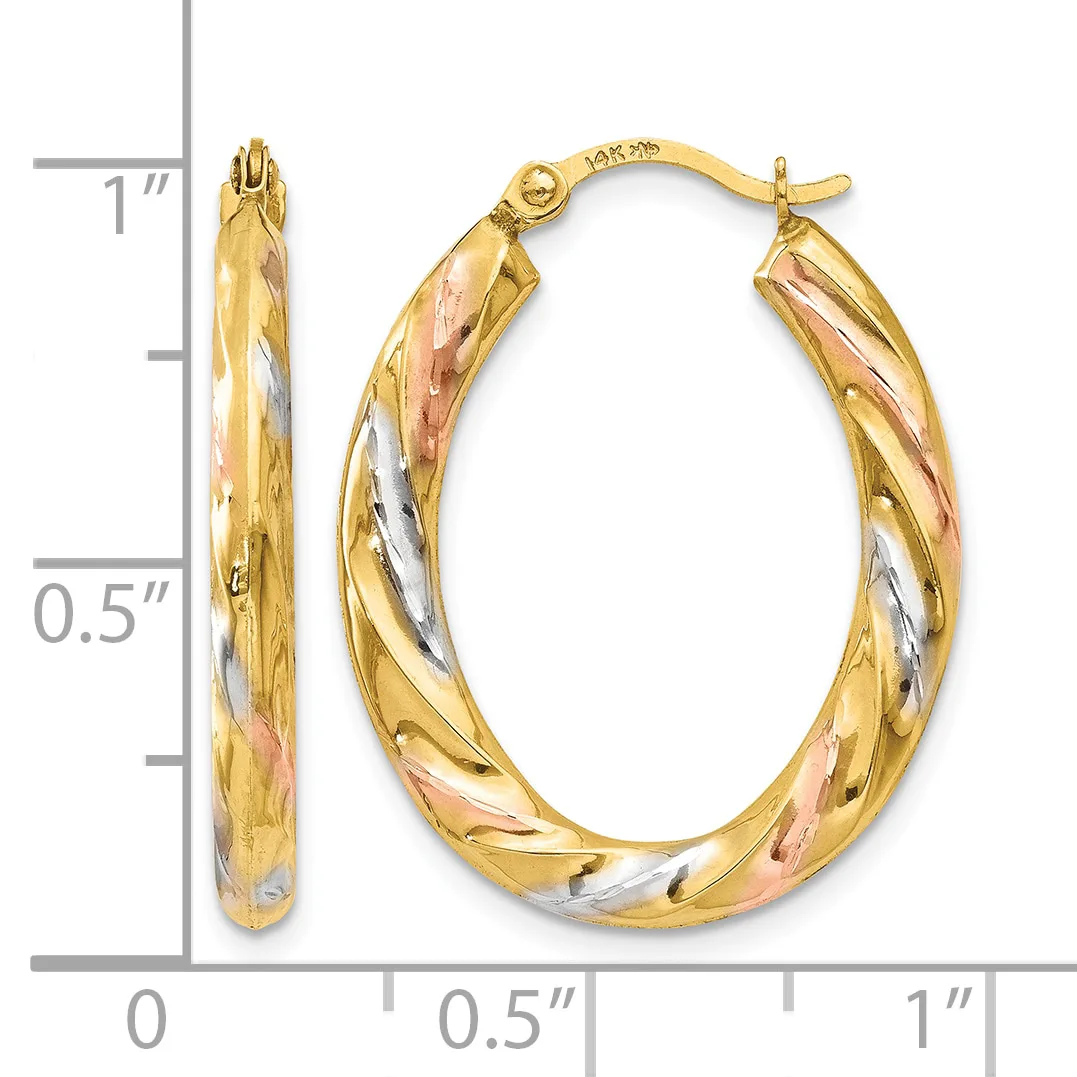 A pair of tri-color gold hoop earrings with twisted diagonal striping, displayed next to a ruler showing approximately one inch in length.