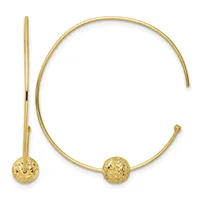 Gold-toned open bangle bracelet with textured spherical ball ends, shown with a matching curved hook earring against a white background.