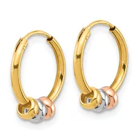 Pair of gold hoop earrings with small decorative beads in white and rose gold hanging from hinged closures.