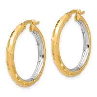 Pair of two-tone gold hoop earrings with a textured outer surface and polished inner surface, shown from the front.