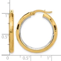 Two-tone gold hoop earrings with a polished finish and hinged posts, displayed against a measurement ruler showing approximately one inch in height.