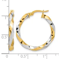 Two-tone twisted hoop earrings with gold and silver sections, shown next to a measurement scale indicating approximately one inch in diameter.