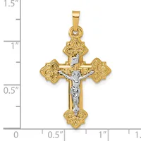 Two-tone gold crucifix pendant with ornate floral design at each of the four ends and a silver-toned corpus, shown against a ruler measuring approximately 1.25 inches tall.
