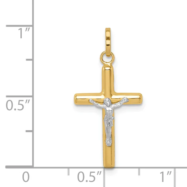 A two-tone gold crucifix pendant with a polished yellow gold cross and a white gold corpus figure, displayed against a measurement scale showing approximately one inch in height.
