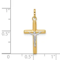 A two-tone gold crucifix pendant with a polished yellow gold cross and a white gold corpus figure, displayed against a measurement scale showing approximately one inch in height.