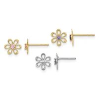 Three pairs of flower-shaped stud earrings displayed side by side: two gold pairs with pink and purple gemstone centers, and one silver pair with a clear gemstone center.