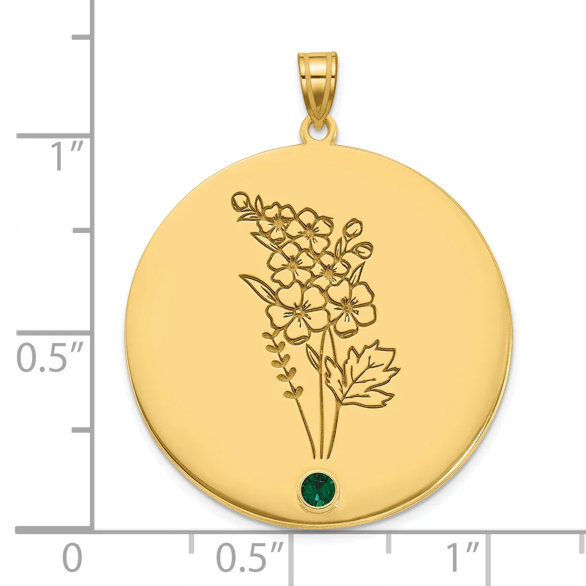 Gold-colored round pendant with engraved flowers and leaves, featuring a small dark green gemstone at the bottom, shown next to a ruler for scale.