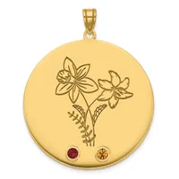 A gold circular pendant with an engraved floral design featuring two flowers and leafy stems, accented with a red gemstone and an orange gemstone at the bottom.
