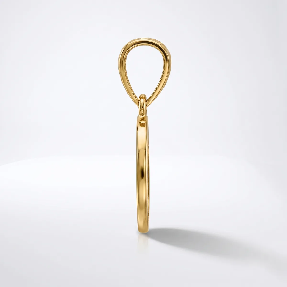 A gold pendant charm in the shape of a teardrop loop with a cylindrical bail, photographed against a white background.