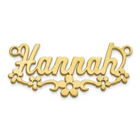 Gold-toned metal name plate pendant spelling "Hannah" with decorative flower motifs along the bottom edge and loop attachments at the corners.